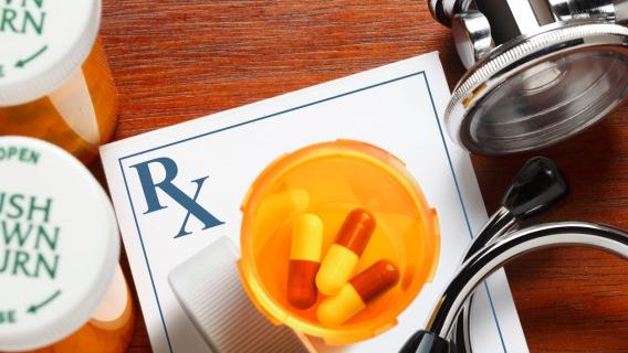 Pills, prescription pad and stethoscope
