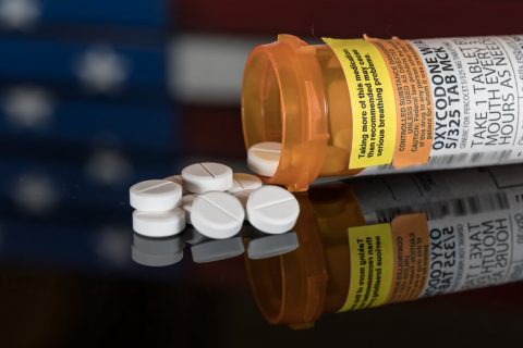 Oxycodone pills with American flag in background