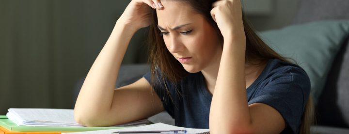 Woman having trouble reading papers on desk