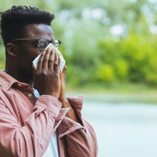 A man sneezing into a tissue.