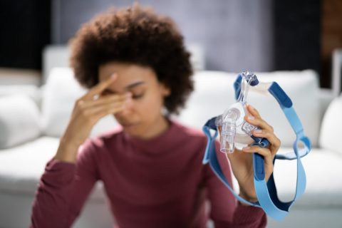 Shocked Young Woman Holding CPAP Machine Mask